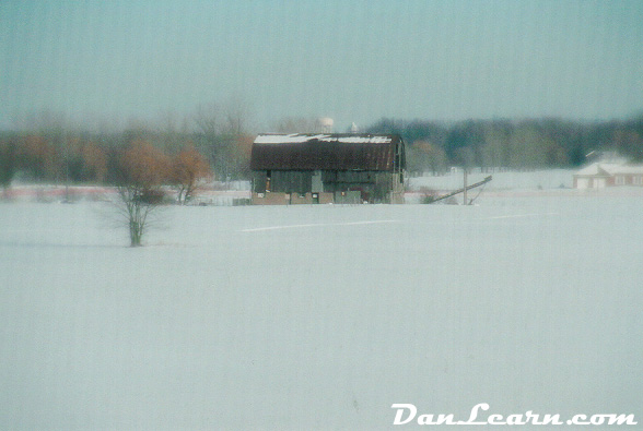 Snow-covered barn and field