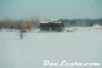 Snow-covered barn and field